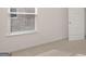 Bedroom with neutral carpet, white walls, and door, next to a window at 100 Silver Moon Dr, Loganville, GA 30052