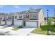 Exterior of townhome featuring brick and siding, attached garages, and manicured lawns offering curb appeal at 100 Silver Moon Dr, Loganville, GA 30052