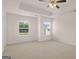 Spacious main bedroom with neutral carpet, a tray ceiling, and natural light coming from bright, sunny windows at 100 Silver Moon Dr, Loganville, GA 30052