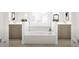 Luxurious bathroom featuring a soaking tub nestled between two vanities with marble backsplash at 799 Grande Bishop Dr, Fairburn, GA 30213