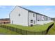 A long view of a townhome complex highlighting its grass lawn and black metal fence at 322 Sound Cir # 118, Stockbridge, GA 30281