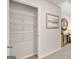 Bright hallway includes coat closet with shelving, neutral paint, carpet, console table with decor and a decorative mirror at 326 Sound Cir # 119, Stockbridge, GA 30281