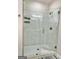 Walk-in shower with frameless glass door and white marble-style tiling at 4438 Encore Park Xing, Duluth, GA 30097