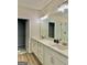 Bathroom vanity featuring double sinks, neutral-toned cabinets, and wood-look tile flooring at 4438 Encore Park Xing, Duluth, GA 30097