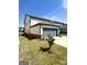Side-entry garage with a gray door, a well-manicured lawn, and a concrete driveway at 4438 Encore Park Xing, Duluth, GA 30097