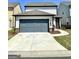 Side-entry garage with a gray door, a well-manicured lawn, and a concrete driveway at 4438 Encore Park Xing, Duluth, GA 30097