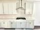 Well-equipped kitchen with stainless steel hood, white cabinets, subway tile backsplash, and gas cooktop at 4438 Encore Park Xing, Duluth, GA 30097