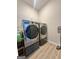 This laundry room features modern stainless steel appliances and wood-look flooring at 4438 Encore Park Xing, Duluth, GA 30097
