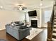 Cozy living room with a fireplace, TV, comfortable seating, and staircase, perfect for relaxation and entertainment at 4438 Encore Park Xing, Duluth, GA 30097