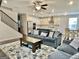 Spacious open-concept living area with staircase, flowing into the kitchen featuring a comfortable lounge area at 4438 Encore Park Xing, Duluth, GA 30097
