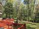 Spacious backyard surrounded by tall mature trees and wooden deck at 275 Summertown Dr, Stockbridge, GA 30281