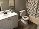 Well-lit bathroom features a white vanity, laminate floors, toilet and tub shower combo with a patterned shower curtain at 275 Summertown Dr, Stockbridge, GA 30281