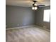 Large gray carpeted bedroom features a ceiling fan and a window letting in natural light at 275 Summertown Dr, Stockbridge, GA 30281