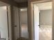 Hallway with multiple doorways leading to carpeted rooms with light neutral paint at 275 Summertown Dr, Stockbridge, GA 30281