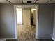 A gray room with laminate floors opens into another room; a white door can be seen in the other room at 275 Summertown Dr, Stockbridge, GA 30281
