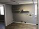 Large gray room features a drop ceiling, laminate floors, shelving, and natural light from an exterior window at 275 Summertown Dr, Stockbridge, GA 30281