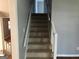 Staircase with carpeted steps and white railing, offering easy access to upper floors at 275 Summertown Dr, Stockbridge, GA 30281