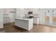 Open-concept kitchen with a large island, modern appliances, granite countertops and hardwood flooring at 334 Sound Cir, Stockbridge, GA 30281