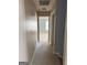 Neutral hallway leading to a carpeted room with a window providing natural light at 117 Rendition Dr, Mcdonough, GA 30253