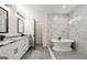 Bright bathroom with white cabinets, marble counters, freestanding tub and glass enclosed shower at 1962 Compton Dr, Atlanta, GA 30315