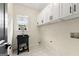 Bright laundry room features white upper cabinets, sink, and window at 1962 Compton Dr, Atlanta, GA 30315