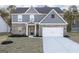 Charming two-story home with a brick and gray exterior, complemented by a well-manicured front yard and a two-car garage at 3353 Arabian Farm Ln, Dacula, GA 30019