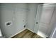 Clean and functional laundry room has door and shelving unit at 695 Park Place Way, Social Circle, GA 30025