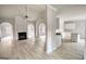 Open living space with wood floors showcases fireplace, kitchen with white cabinets, and archways at 695 Park Place Way, Social Circle, GA 30025