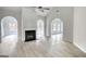 Light-filled living room showcasing a fireplace, archways, wood floors, and multiple windows at 695 Park Place Way, Social Circle, GA 30025