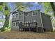 Two-story house with a wooden deck, steps, and a backdrop of lush greenery in the backyard at 1397 Thomas Rd, Decatur, GA 30030