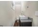 Modern powder room with a vessel sink on a dark cabinet, a toilet, and a small window at 1397 Thomas Rd, Decatur, GA 30030