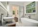 Bathroom featuring double sinks, modern fixtures, soaking tub, and window views at 1397 Thomas Rd, Decatur, GA 30030