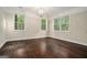 Spacious bedroom with hardwood floors, three windows, and a stylish chandelier at 1397 Thomas Rd, Decatur, GA 30030