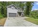 Two-story home featuring a two-car garage, stone accents, covered porch, and a concrete driveway at 1397 Thomas Rd, Decatur, GA 30030