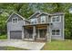 Charming two-story home with gray siding, stone accents, covered porch, and a two-car garage at 1397 Thomas Rd, Decatur, GA 30030