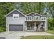 Charming two-story home with gray siding, stone accents, covered porch, and a two-car garage at 1397 Thomas Rd, Decatur, GA 30030