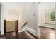 Hallway with dark hardwood floors, a unique chandelier, and view into another room with a window seat at 1397 Thomas Rd, Decatur, GA 30030