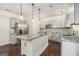 Bright kitchen with a center island, stainless appliances, gray cabinets, granite counters, and stylish hanging lamps at 1397 Thomas Rd, Decatur, GA 30030