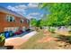 The backyard showcases a spacious layout, a red swing set, patio and green grass, ideal for outdoor activities at 5845 Princeton Run Trl, Tucker, GA 30084