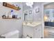 Bathroom featuring a single sink vanity, wood shelves, and decorative mirror at 5845 Princeton Run Trl, Tucker, GA 30084