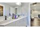 Bright bathroom featuring double sinks, white cabinets and countertops, and modern fixtures at 5845 Princeton Run Trl, Tucker, GA 30084