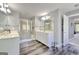 Bright bathroom with dual sinks, glass enclosed shower, and dark hardwood floors at 5845 Princeton Run Trl, Tucker, GA 30084