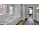 Bright bathroom with dual windows over a soaking tub and dark hardwood floors at 5845 Princeton Run Trl, Tucker, GA 30084