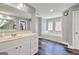 Bright bathroom with dual windows over a soaking tub, dual sinks, and dark hardwood floors at 5845 Princeton Run Trl, Tucker, GA 30084