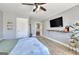 Bedroom with light walls, wood-look flooring, a large bed, and a mounted television at 5845 Princeton Run Trl, Tucker, GA 30084