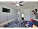 Bedroom with light gray walls, wood-look flooring, a large bed, and a modern ceiling fan at 5845 Princeton Run Trl, Tucker, GA 30084