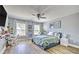 Bright bedroom with light walls, wood-look flooring, a large bed, and a modern ceiling fan at 5845 Princeton Run Trl, Tucker, GA 30084