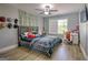 Bedroom with light gray walls, wood-look flooring, a large bed, and a modern ceiling fan at 5845 Princeton Run Trl, Tucker, GA 30084