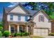 Charming two-story home featuring a stone porch, gray siding, and a well-manicured front yard at 5845 Princeton Run Trl, Tucker, GA 30084
