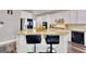 Bright kitchen with white cabinetry and a beautiful island with barstool seating at 5845 Princeton Run Trl, Tucker, GA 30084